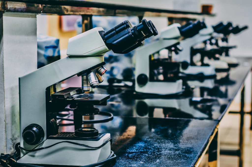 A teaching microscope on a lab table in a classroom.